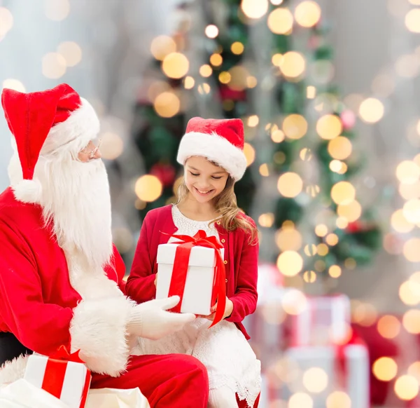 Noel Baba ve hediyeler ile gülümseyen küçük kız — Stok fotoğraf