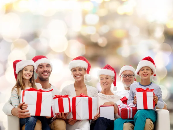 Щаслива сім'я в капелюхах Санта помічника з подарунковими коробками — стокове фото