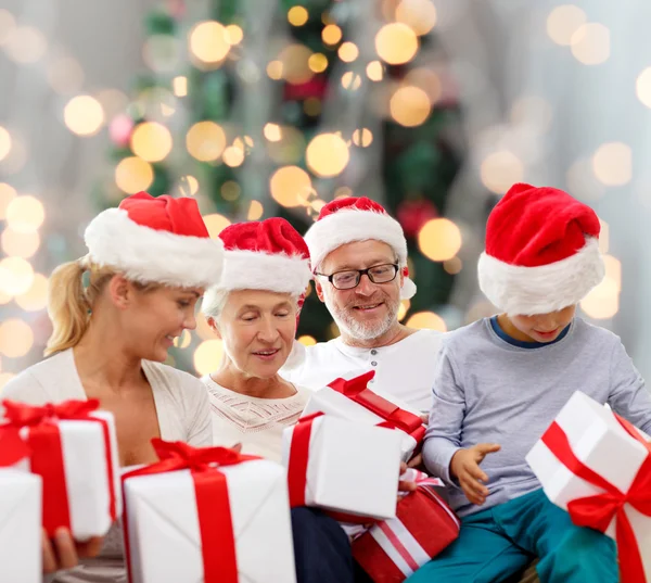 Família feliz em santa helper chapéus com caixas de presente — Fotografia de Stock