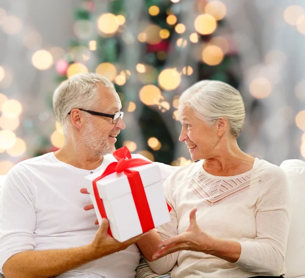 Feliz pareja de ancianos con caja de regalo en casa —  Fotos de Stock