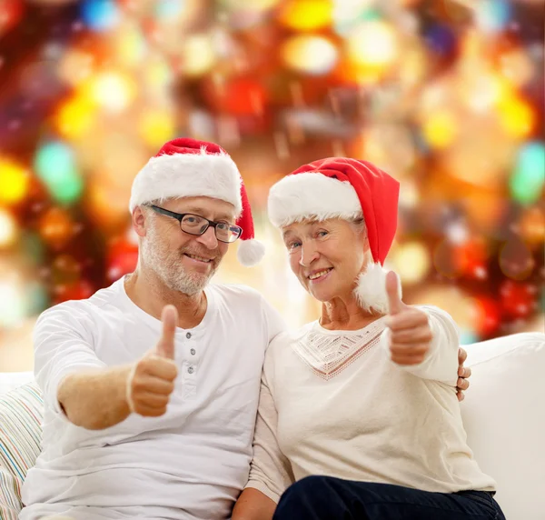 Happy senior couple in santa helper hats — Stock Photo, Image