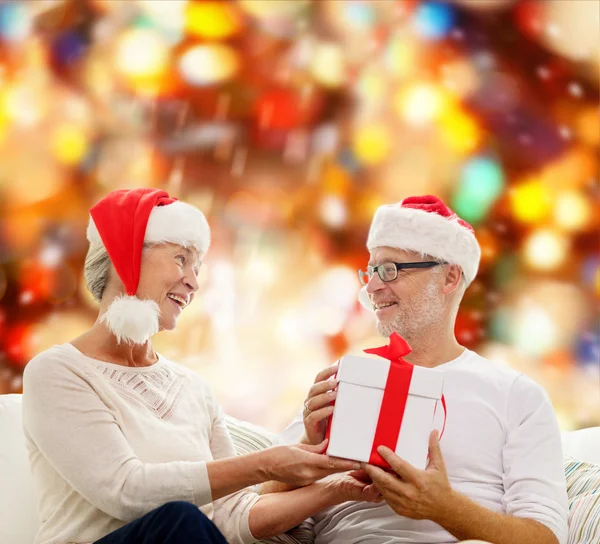 Feliz casal sênior com caixa de presente em casa — Fotografia de Stock