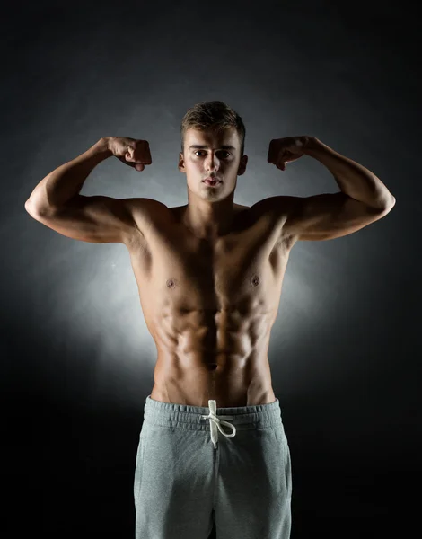 Young man showing biceps — Stock Photo, Image