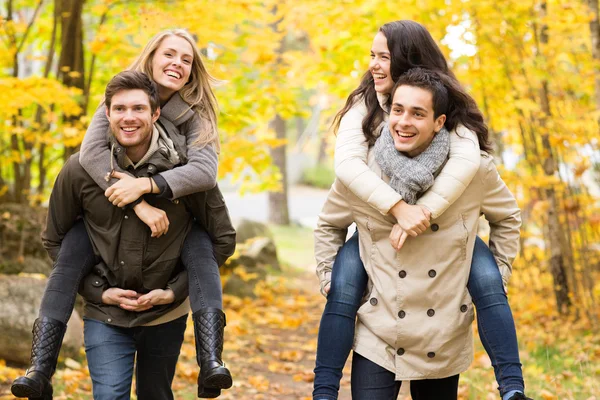 Amis souriants s'amuser dans le parc d'automne — Photo