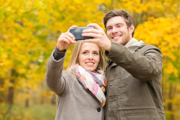 Casal sorridente abraçando no parque de outono — Fotografia de Stock