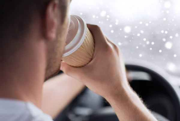 Close up of man drinking coffee while driving car — Stock Photo, Image