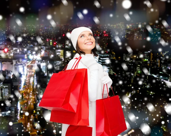 Sonriente joven con bolsas de compras rojas —  Fotos de Stock