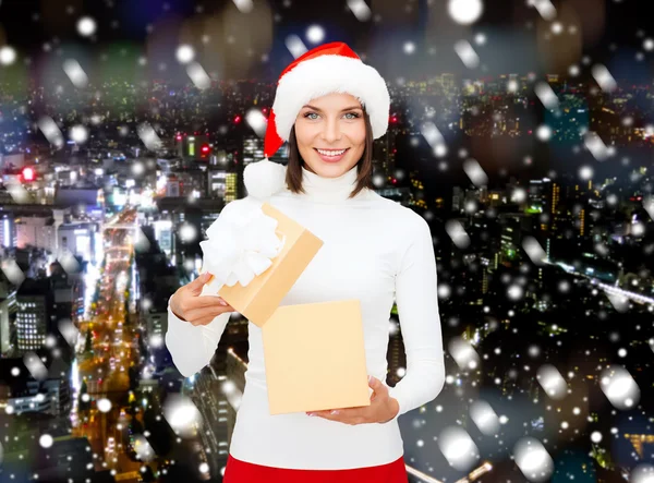 Lachende vrouw in helper kerstmuts met een doos van de gift — Stockfoto