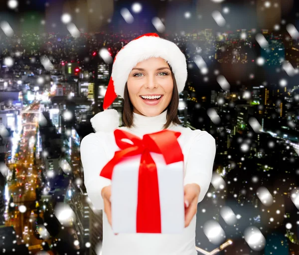 Donna sorridente in cappello Babbo Natale helper con confezione regalo — Foto Stock