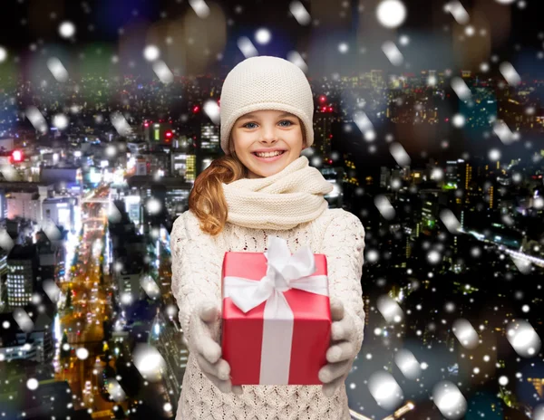 Мечтающая девушка в зимней одежде с подарочной коробкой — стоковое фото