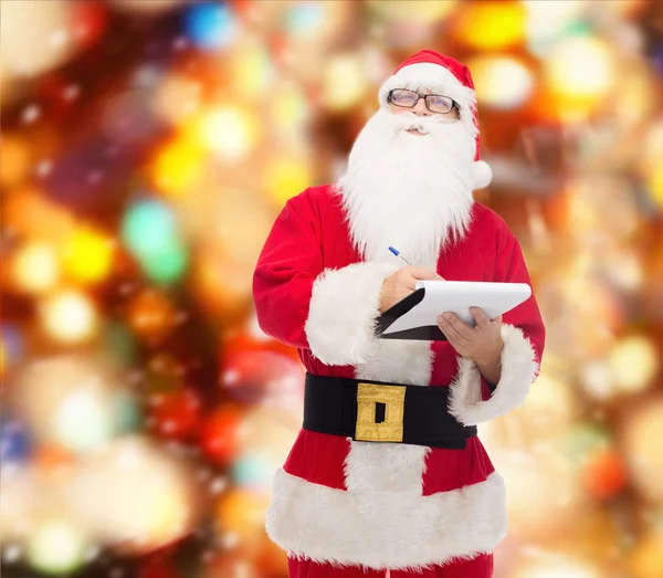 Man in costume of santa claus with notepad — Stock Photo, Image