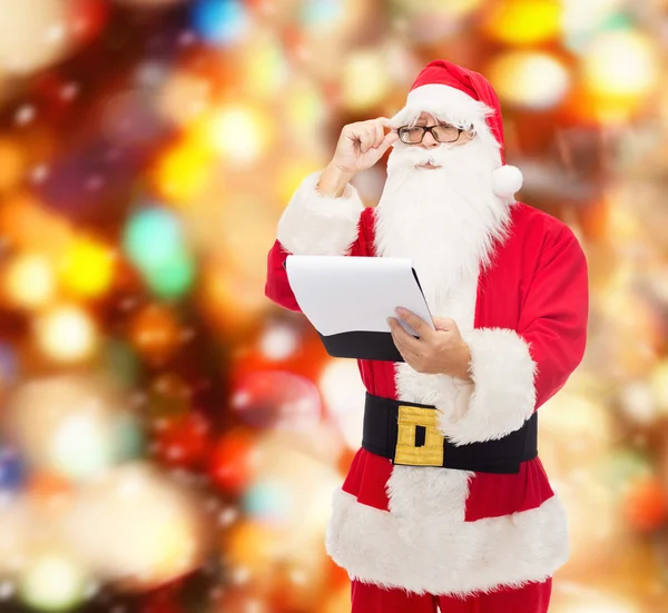 Man in costume of santa claus with notepad — Stock Photo, Image