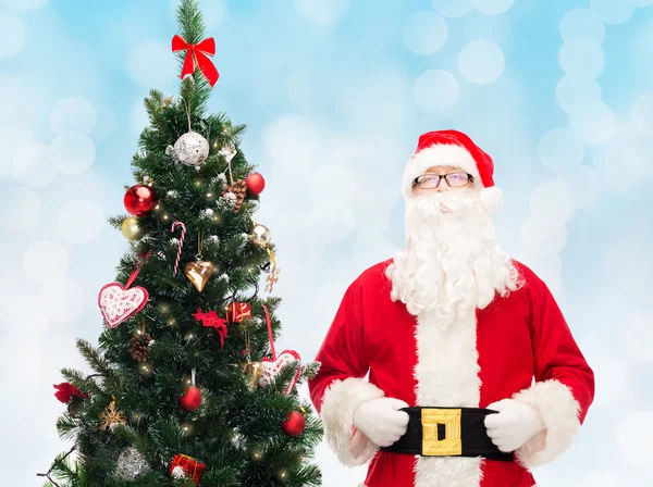 Homem em traje de santa claus com árvore de natal — Fotografia de Stock