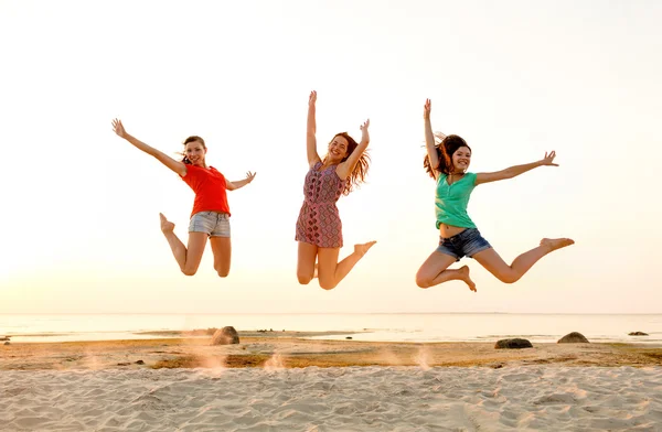 Lachende tiener meisjes springen op strand — Stockfoto