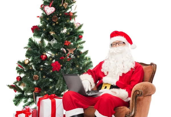 Man in costume of santa claus with laptop — Stock Photo, Image