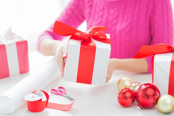 Zamknij się z kobietą, którą dekorowanie świątecznych prezentów — Zdjęcie stockowe