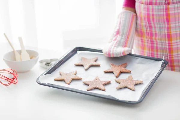 Nahaufnahme einer Frau mit Keksen auf Backblech — Stockfoto