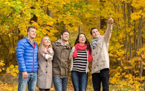 Gruppo di uomini e donne sorridenti nel parco autunnale — Foto Stock