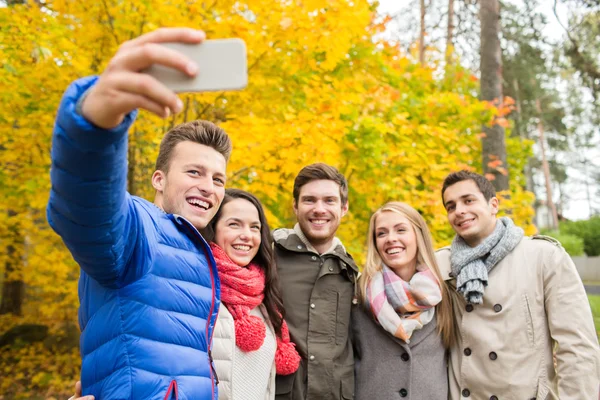 Arkadaş grubu smartphone Şehir Parkı içinde gülümseyen — Stok fotoğraf