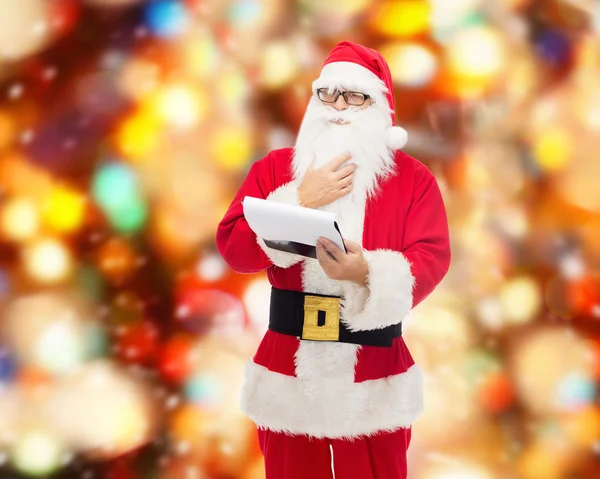 Man in costume of santa claus with notepad — Stock Photo, Image