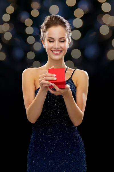 Donna sorridente in possesso di scatola regalo rossa — Foto Stock