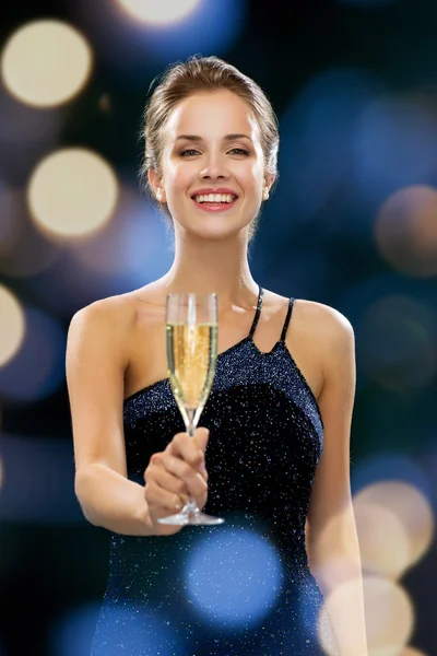 Sonriente mujer sosteniendo un vaso de vino espumoso —  Fotos de Stock