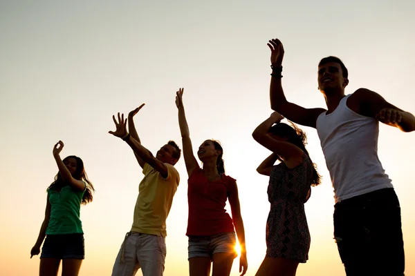 Amigos sonrientes bailando en la playa de verano — Foto de Stock