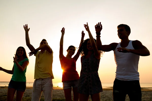 Amigos sonrientes bailando en la playa de verano — Foto de Stock