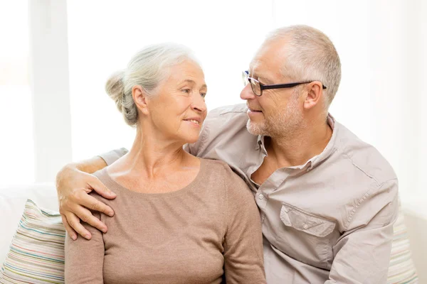 Gelukkige senior paar knuffelen op sofa thuis — Stockfoto