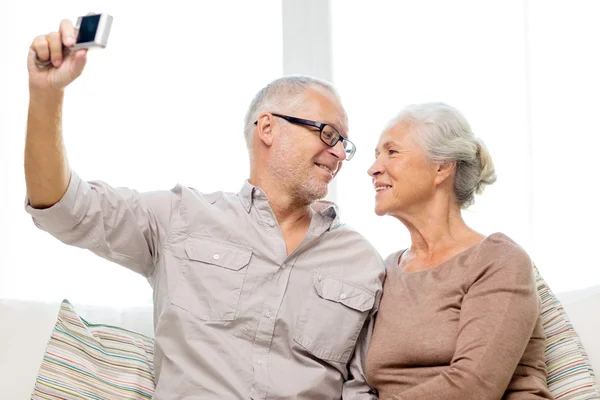 Glückliches Seniorenpaar mit Kamera zu Hause — Stockfoto