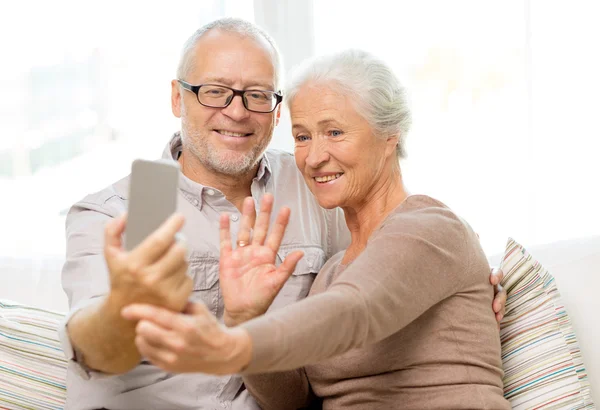 Casal sênior feliz com smartphone em casa — Fotografia de Stock