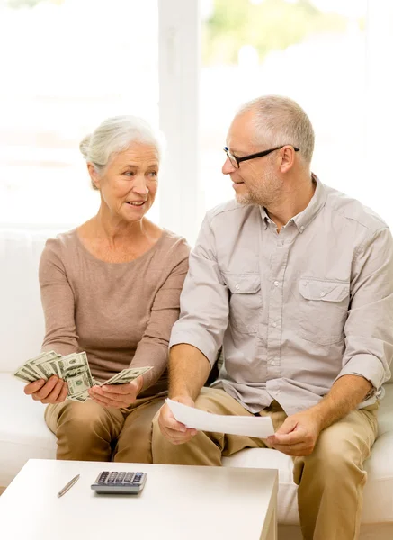 Senior couple with money and calculator at home — Stock Photo, Image
