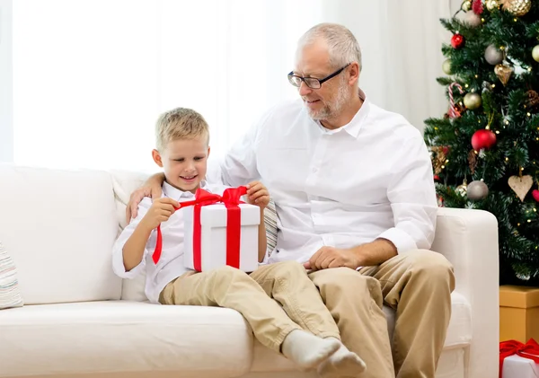 Smiling grandfather and grandson with gift box — Stock Photo, Image