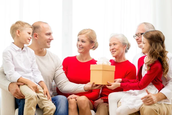 Smiling family with gift at home — Stock Photo, Image