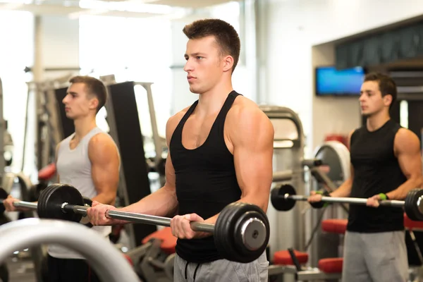 Grupo de hombres con barras en el gimnasio — Foto de Stock