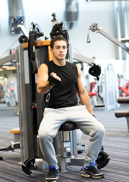 Hombre haciendo ejercicio en la máquina de gimnasio — Foto de Stock