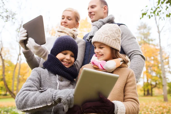 Szczęśliwa rodzina z komputera typu tablet w parku jesień — Zdjęcie stockowe