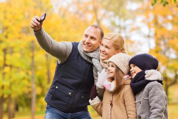 Famiglia felice con macchina fotografica nel parco autunnale — Foto Stock