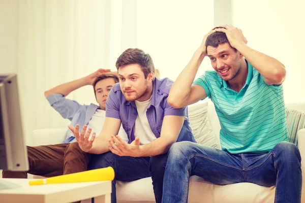 Triste masculino amigos com vuvuzela assistindo esportes — Fotografia de Stock