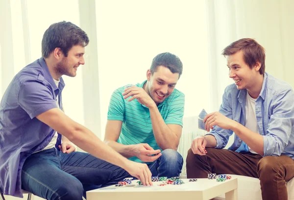 Glücklich drei männliche Freunde, die zu Hause Poker spielen — Stockfoto