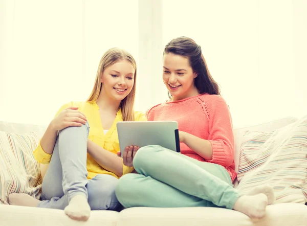 两个微笑少女与平板电脑在家里 — 图库照片