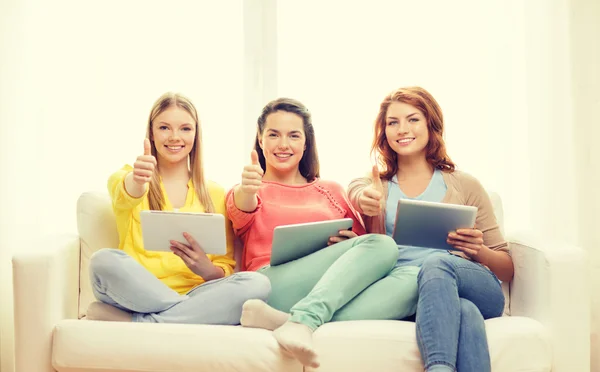 Três meninas adolescentes sorridentes com tablet pc em casa — Fotografia de Stock