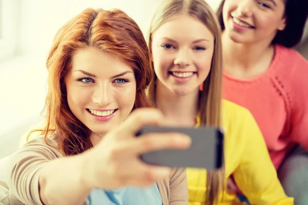 Chicas adolescentes sonrientes con teléfono inteligente en casa —  Fotos de Stock