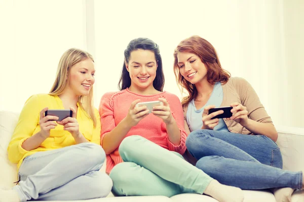 Uśmiechnięty nastoletnich dziewcząt ze smartfonów w domu — Zdjęcie stockowe