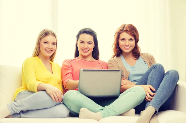 Tres niñas adolescentes sonrientes con ordenador portátil en casa —  Fotos de Stock