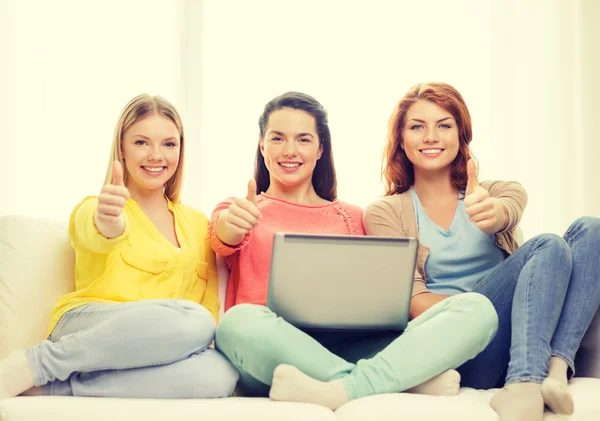 Drie glimlachend tienermeisjes met laptop thuis — Stockfoto