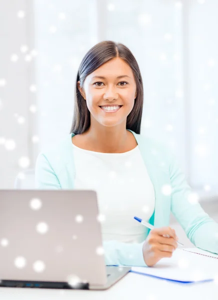 Giovane donna sorridente con computer portatile e notebook — Foto Stock