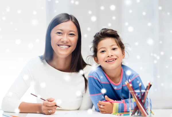 Mãe e filha com lápis para colorir dentro de casa — Fotografia de Stock