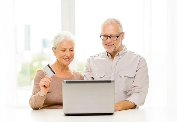 Happy senior couple with laptop and credit card — Stock Photo, Image