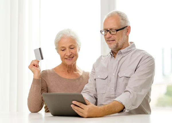 Feliz pareja de ancianos con tableta PC y tarjeta de crédito —  Fotos de Stock